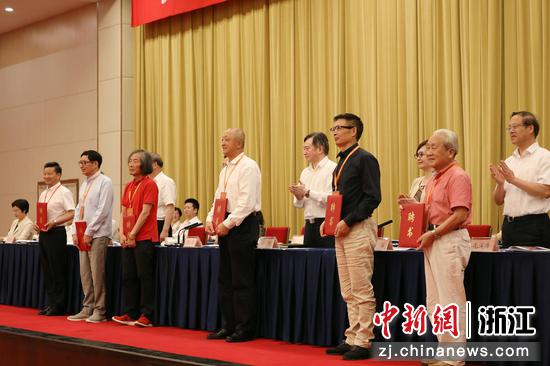 会议现场，王冬龄、朱炳仁、刘恒、麦家、杜高杰、翁仁康接受第九届名誉主席聘书。杭州市文联供图