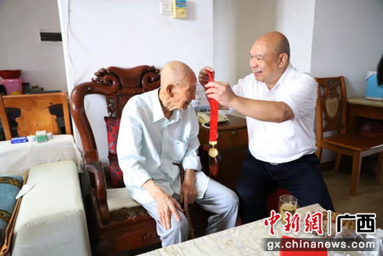 韦周凡给王俊林佩戴“光荣在党50年”纪念章 广西农机中心供图 广西农机中心开展走访慰问老党员老干部活动