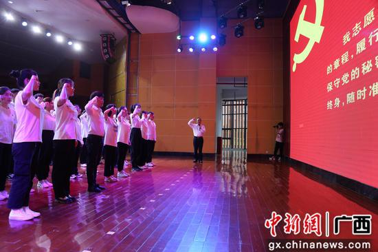 柳州工学院党委书记罗云贵带领新党员入党宣誓、老党员重温入党誓词。赵世奇 摄 柳州工学院举行“两优一先”表彰大会