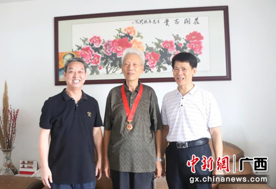 黄汉全(左一)到纪念章获得者杨建亭家中走访慰问 广西农机中心供图 广西农机中心开展走访慰问老党员老干部活动