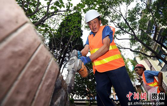 图为7月6日，在贵阳市南明区西湖路街道“三感社区”试点项目建设现场，施工工人正在进行绿化带提升作业。