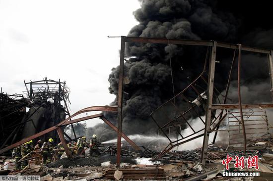 当地时间7月5日凌晨，泰国北榄府一家化工厂发生爆炸事故。当地官员称，事故已造成1名救援人员遇难，29人受伤。图为消防员进行灭火。