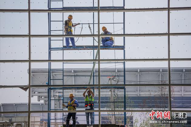 7月7日，中建深圳装饰北方分公司的建设者在国家会展中心（天津）二期项目进行外幕墙施工。当日是“小暑”节气，众 多建设者坚守在国家会展中心（天津）二期工程施工现场。国家会展中心（天津）是中国商务部和天津市政府合作共建的 重点项目。目前，国家会展中心（天津）一期已投入使用，二期工程建设正在有序进行。

中新社记者 佟郁 摄