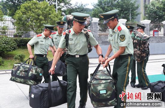 图为武警贵阳支队班长们帮新兵搬运行李。 罗园 摄