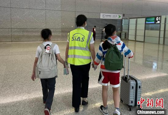 上海机场地服公司工作人员帮助无人陪伴儿童登机。　上海机场集团供图