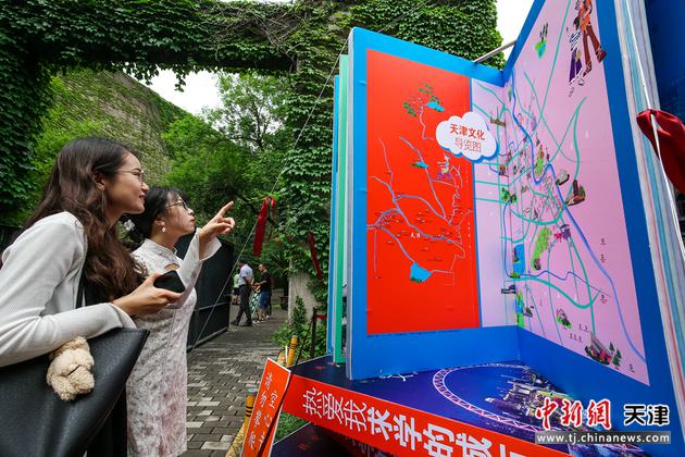 图为两名天津大学学生在校园内观看《天津文化地图》新书模型。