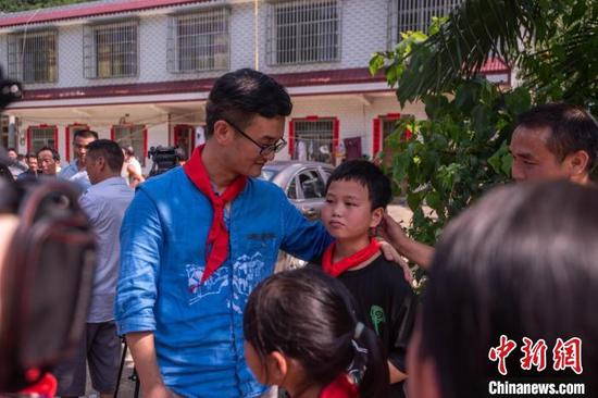 战马小学的学生和张冬冬依依不舍地告别。 唐哲 摄 战马小学的学生和张冬冬依依不舍地告别。 唐哲 摄