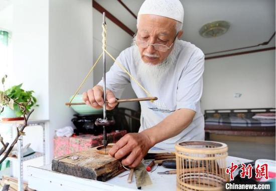 7月中旬，甘肃天水市“竹雕大师”吴云生借助工具手工打眼。　高展　摄