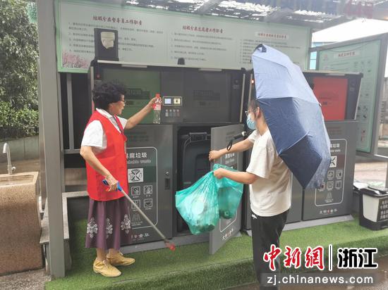 黄银桂指导一位居民投放垃圾。王江 摄