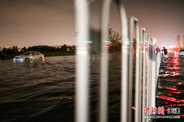 7月13日，天津，暴雨过后，一辆汽车搁浅在积水中。