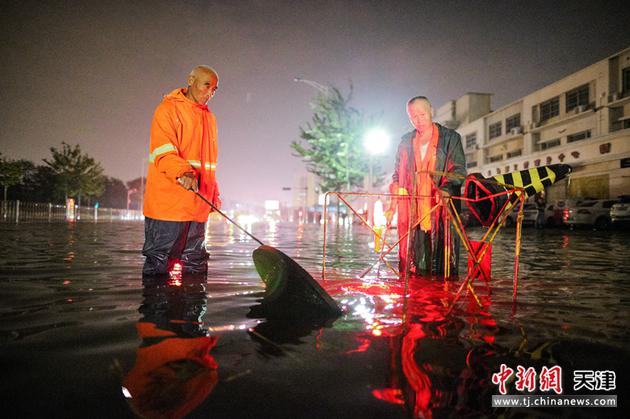 7月13日，天津排水工作人员在积水路段进行排水作业。当晚，天津市气象台发布暴雨蓝色预警信号。
中新社记者 佟郁 摄