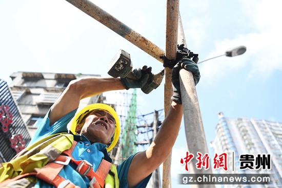 7月14日，在贵阳市南明区兴隆片区老旧小区改造项目建设现场，工人正在进行外架搭设加固。