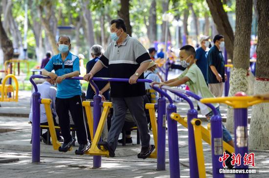 7月15日，新疆乌鲁木齐市体育公园，民众利用公共健身器械锻炼身体。据介绍，该市正推进城区“15分钟体育健身圈”建设，将在不少于150个小区、公园、小游园等场所新建一批以室外为主的公共体育设施。 中新社记者 刘新 摄