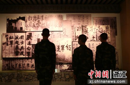 新战友们驻足于红军宣传标语墙前。刘治乾 摄