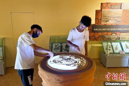 留学生在中国防沙治沙展览馆体验沙画。　李佩珊 摄