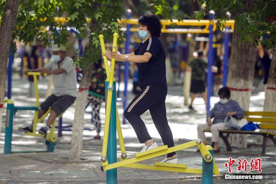 7月15日，新疆乌鲁木齐市体育公园，市民利用公共健身器械锻炼身体。据介绍，该市正推进城区“15分钟体育健身圈”建设，将在不少于150个小区、公园、小游园等场所新建一批以室外为主的公共体育设施。 中新社记者 刘新 摄