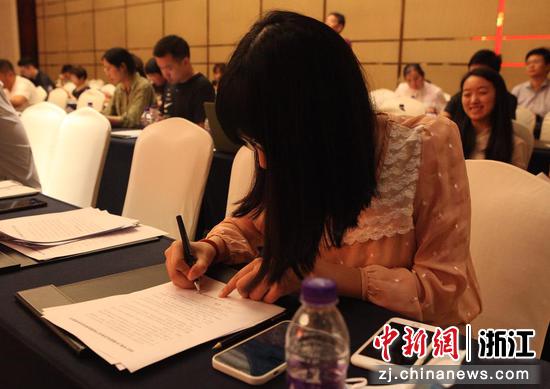 一家被授权使用杭州亚运会特殊标志的企业相关负责人正在签署企业承诺书。胡亦心 摄