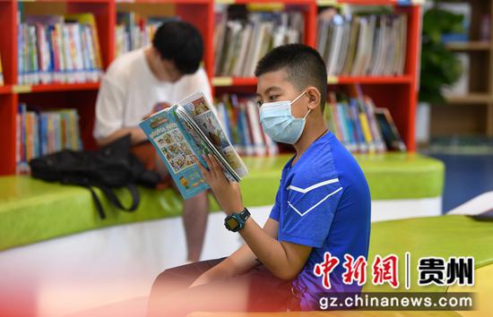 7月21日，一名小读者正在贵阳市南明区图书馆内阅读儿童图书。