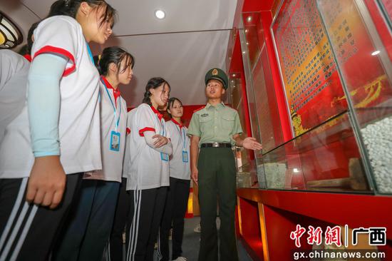 春蕾女童参观某中队荣誉室，武警官兵讲述故事。李灿明 摄
