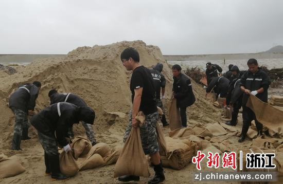 工作人员铲泥沙装沙袋，在海岸线“查漏补缺”。蚂蚁岛管委会 供图