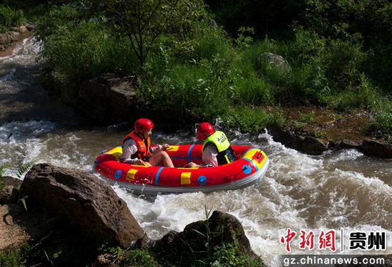 游客在贵州省黔西市中建乡中果河峡谷漂流。