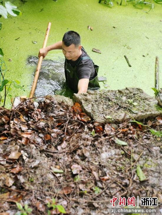 70后村支纵身跳进齐腰深的水流  张斌 摄