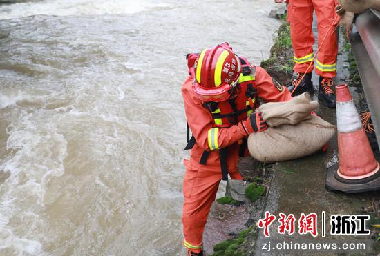 7月26日，义乌市消防救援支队救援人员用沙袋填堵河道缺口。  陈文青（通讯员） 摄