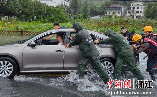 
7月26日，绍兴市上虞区消防救援大队指战员将车辆推出积水区域。  绍消 供图