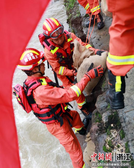
7月26日，义乌市消防救援支队救援人员用沙袋填堵河道缺口。  陈文青（通讯员） 摄