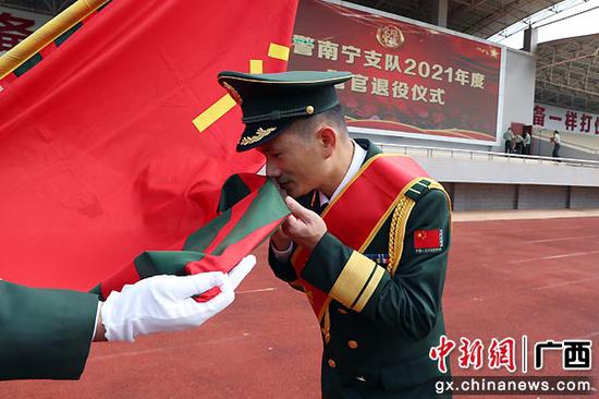 图为退役警官向武警部队旗告别。李海潇 董亚涛  摄影报道