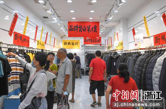 一家商铺打出“品牌货白菜价”的促销语。王刚 摄