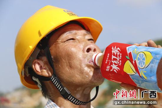 工人喝饮料解暑。