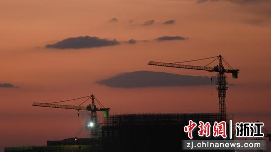 一建筑工地之外的晚霞酷似红色云海。  王刚 摄