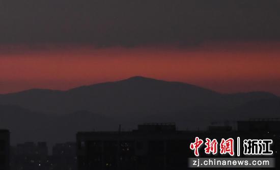 杭州群山与云层之间出现绯红晚霞。  王刚 摄