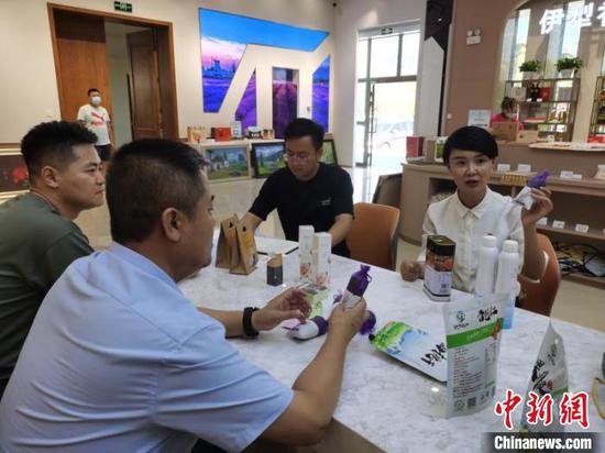 “网红局长”贺娇龙（右一）与工作人员一起对接直播产品选品事宜。　王志华　摄