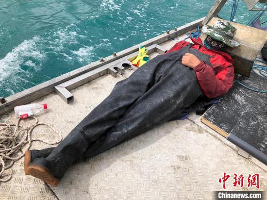 科考队员在高原湖泊的钻探平台上累了临时就地休息。　中新社记者 孙自法 摄