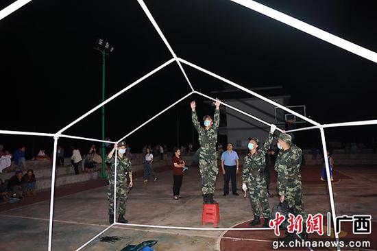 8月5日，武警百色支队官兵组织搭建临时场所。张轩  摄