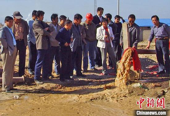 2008年9月，王惠玲和职工见证了山丹县新打的供水机井通水，该供水井解决了长城新村居民用水难问题。　雷华　摄