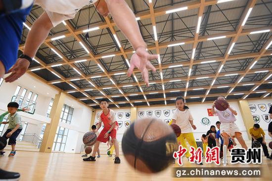 8月9日，贵阳市南明区花果园第二小学的老师正在篮球馆指导学生进行运球技巧训练。