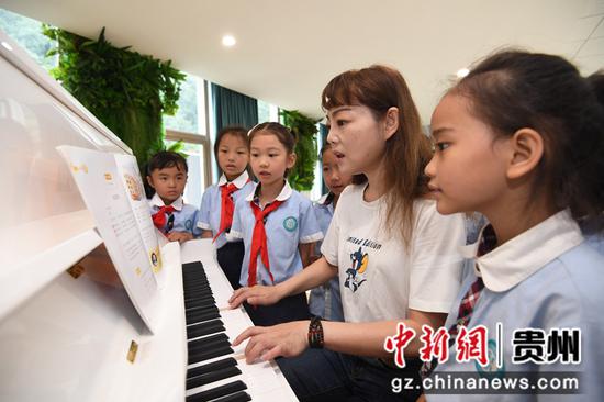 8月9日，贵阳市南明区花果园第二小学的老师正在该校音乐角带着学生唱儿歌。