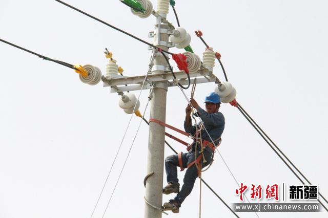 8月4日，巴州焉耆县农村电网改造升级工程正在进行，电力工人正在爬杆作业。