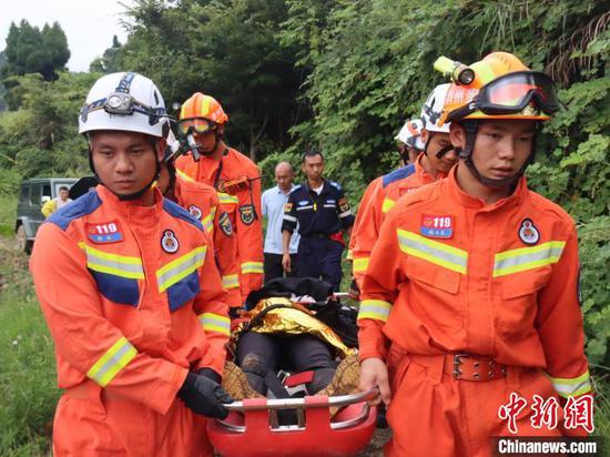 图为消防员利用担架将受伤驴友抬出。　绥阳县消防救援大队 供图