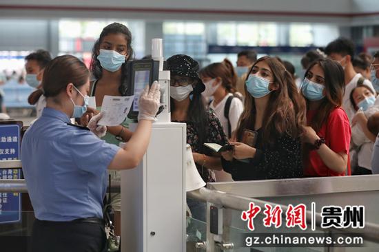 海外旅客在贵阳北站候车大厅检票。 瞿宏伦  摄