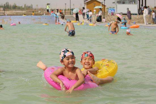 图为：新疆和硕县滨河景观带露天游泳池内孩子正在游泳（3） 苏强摄。
