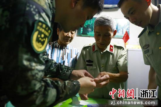 傅良生给官兵们展示他当兵时的纪念章。李搏 摄