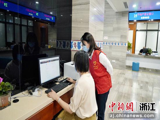 景宁县烟草专卖局窗口工作人员叶茹洁（右）指导群众申请线上办证业务。王艳 摄