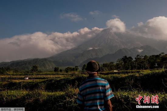 当地时间8月16日，当地村民眺望默拉皮火山。