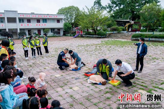 图为王家义老师和吴雨峰队长指导志愿者和教职工进行心肺复苏演示。 劳业铭 摄