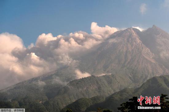 当地时间8月16日，从日惹的Sleman远眺默拉皮火山，火山口附近烟尘滚滚。