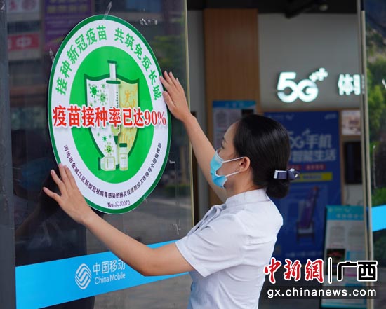 在河池市金城江区,移动营业厅工作人员张贴由当地新冠肺炎疾控工作领导小组认证的“疫苗接种率已达90%”标识。 在河池市金城江区,移动营业厅工作人员张贴由当地新冠肺炎疾控工作领导小组认证的“疫苗接种率已达90%”标识。